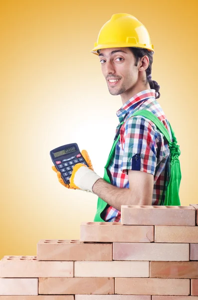 Expensive construction concept with builder and calculator — Stock Photo, Image