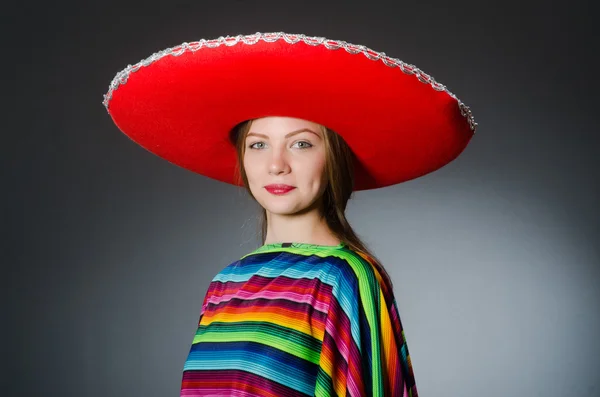 Menina em mexicano poncho vívido contra cinza — Fotografia de Stock