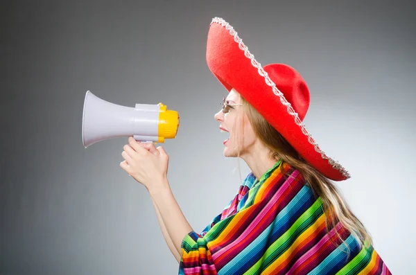 Lány mexikói élénk poncho tartja hangszóró ellen szürke — Stock Fotó