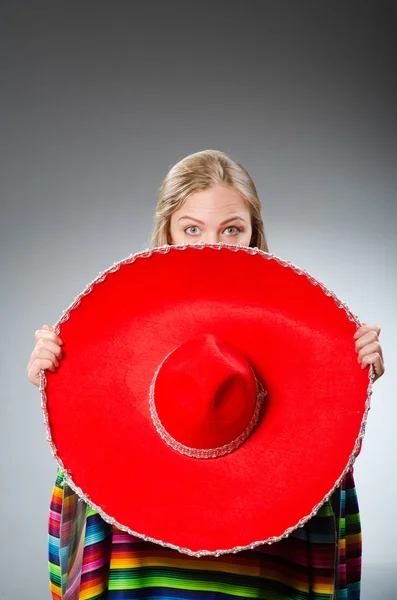 Flicka i mexikanska levande poncho mot grå — Stockfoto