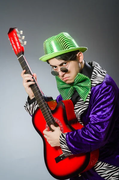 Homem engraçado tocando guitarra no conceito musical — Fotografia de Stock