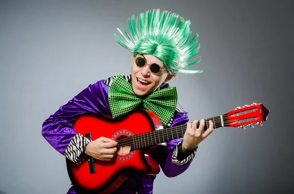 Homem engraçado tocando guitarra no conceito musical — Fotografia de Stock