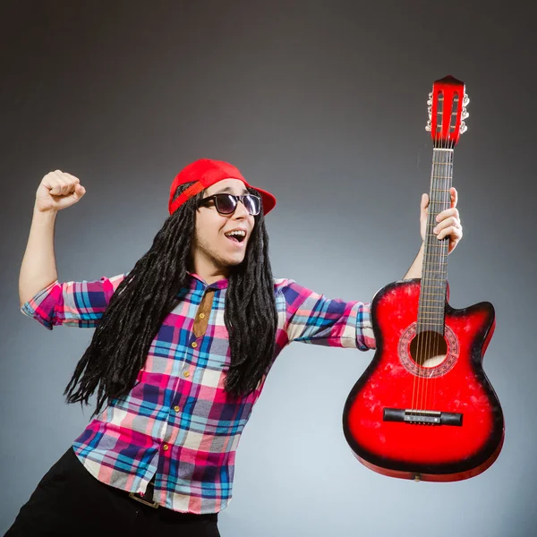 Homem engraçado tocando guitarra no conceito musical — Fotografia de Stock