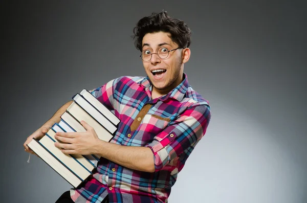 Estudante engraçado com muitos livros — Fotografia de Stock