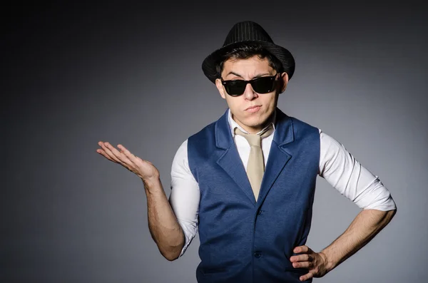 Hombre joven en chaleco azul oscuro y sombrero contra gris —  Fotos de Stock