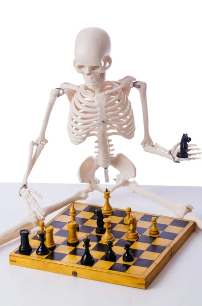 Squelette jouant au jeu d'échecs sur blanc — Photo