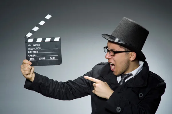 Detective de casaco preto com clapperboard contra cinza — Fotografia de Stock