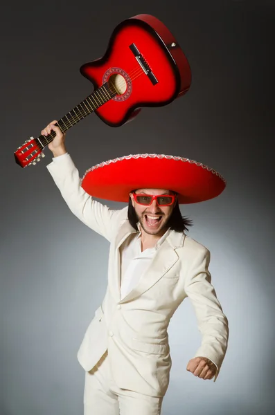 Mexicano engraçado em terno segurando guitarra contra cinza — Fotografia de Stock