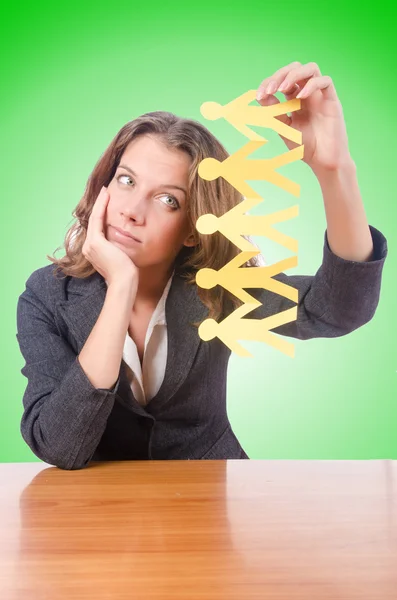 Businesswoman with paper people on green — Stock Photo, Image