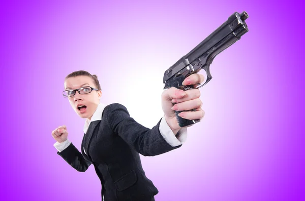 Žena s pistolí izolovaných na fialová — Stock fotografie