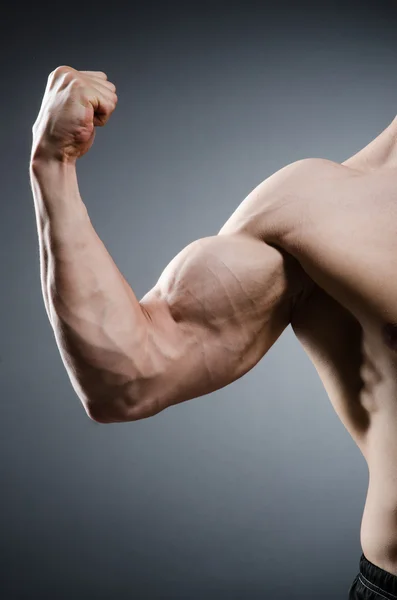 Homem muscular posando em estúdio escuro — Fotografia de Stock