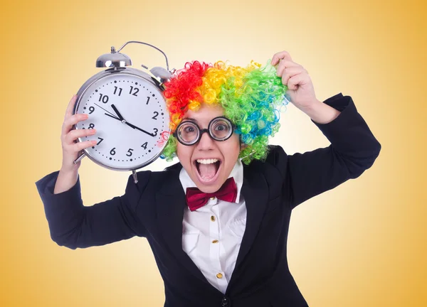 Смешной клоун с часами на желтом — стоковое фото