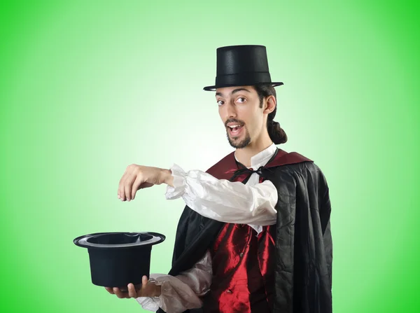 Kouzelník dělá triky na zelené — Stock fotografie