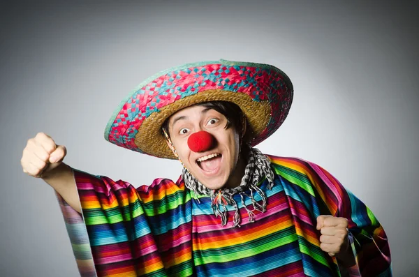 Man in vivid mexican poncho against gray