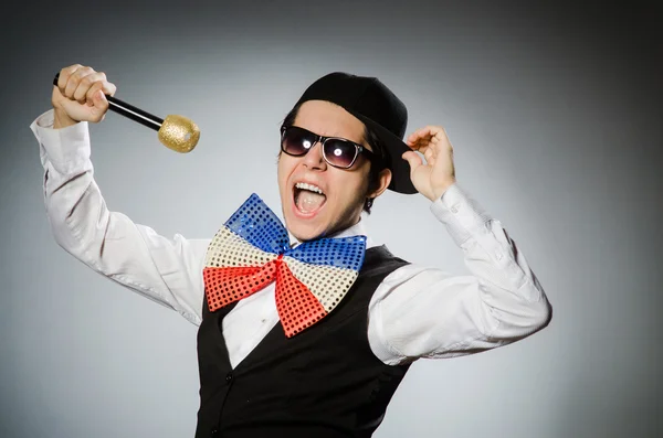 Lustiger Mann mit Mikrofon im Karaoke-Konzept — Stockfoto