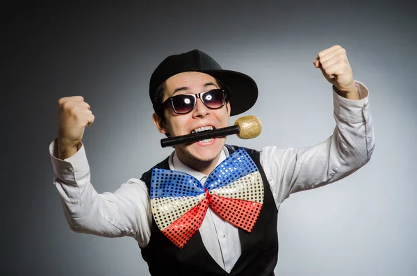 Homem engraçado com microfone no conceito de karaoke — Fotografia de Stock