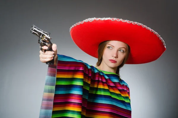 Menina no mexicano poncho vívido segurando arma contra cinza — Fotografia de Stock