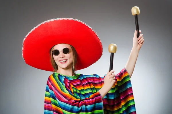 Meisje in mexicaanse levendige poncho met maracas tegen grijs — Stockfoto