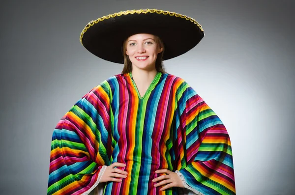 Menina em mexicano poncho vívido contra cinza — Fotografia de Stock