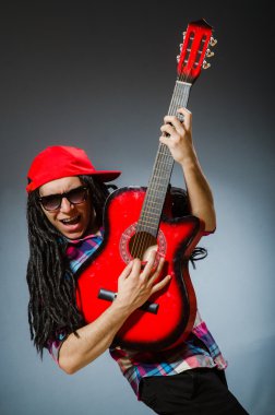Müzik konseptinde gitar çalan komik bir adam.