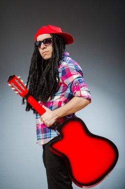 Müzik konseptinde gitar çalan komik bir adam.
