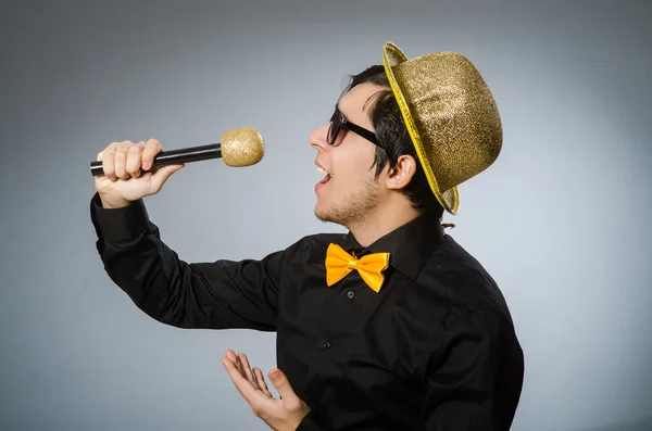 Смешной человек с микрофоном в караоке концепции — стоковое фото