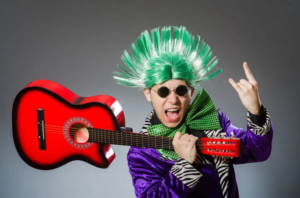 Homem engraçado tocando guitarra no conceito musical — Fotografia de Stock