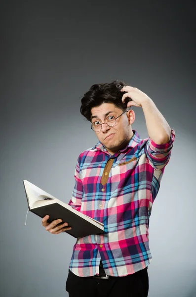 Estudante engraçado com muitos livros — Fotografia de Stock