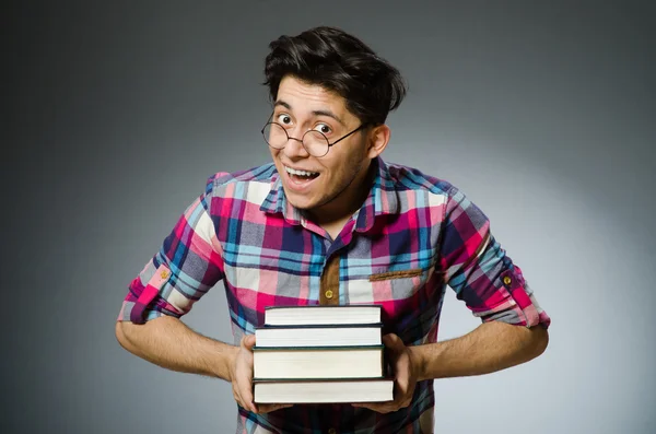 Estudante engraçado com muitos livros — Fotografia de Stock