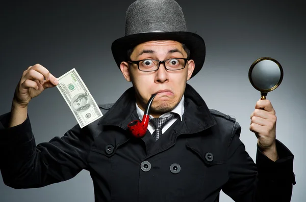 Ung detektiv i svart rock med pengar mot grå — Stockfoto