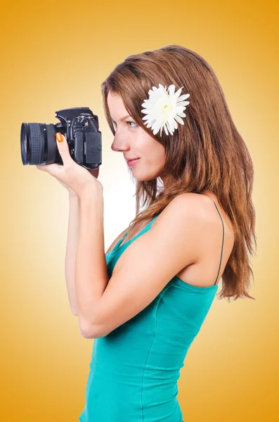 Attractive female photographer on yellow — Stock Photo, Image