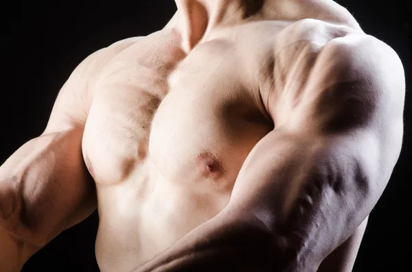 Hombre musculoso posando en estudio oscuro — Foto de Stock