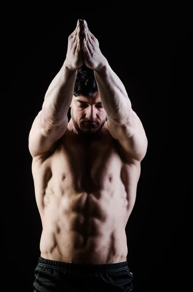 Muscular man posing in dark studio — Stock Photo, Image