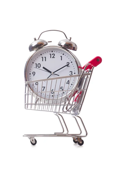 Big alarm clock in shopping cart on white — Stock Photo, Image