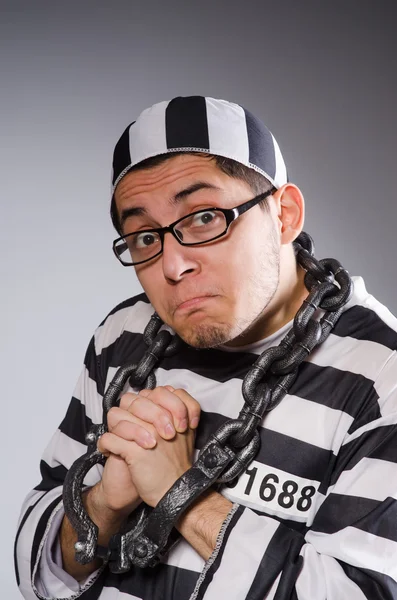 Young prisoner in chains against gray — Stock Photo, Image