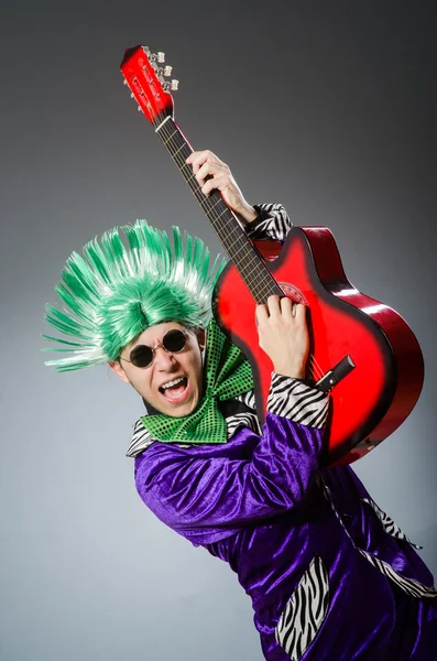 Homem engraçado tocando guitarra no conceito musical — Fotografia de Stock