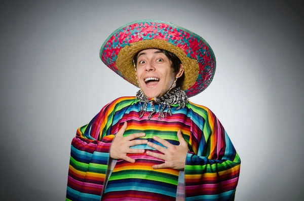 Man in levendige Mexicaanse poncho tegen grijs — Stockfoto