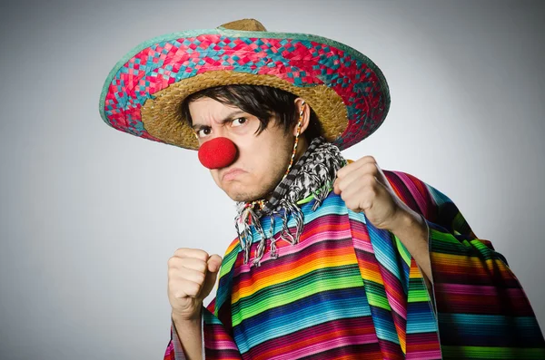 Man in levendige Mexicaanse poncho tegen grijs — Stockfoto