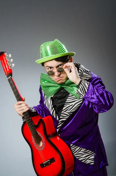 Grappige man die gitaar speelt in muzikaal concept — Stockfoto