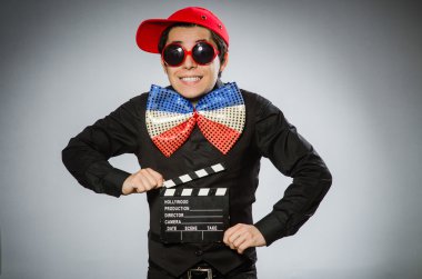 Elinde film tahtası olan komik bir adam.