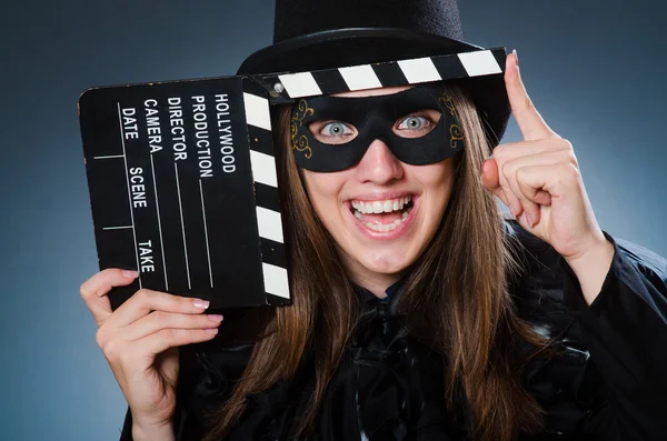Woman wearing mask with movie board — Stock Photo, Image
