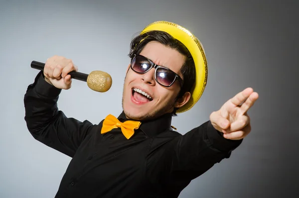 Lustiger Mann mit Mikrofon im Karaoke-Konzept — Stockfoto