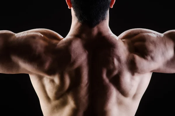 Hombre musculoso posando en estudio oscuro — Foto de Stock