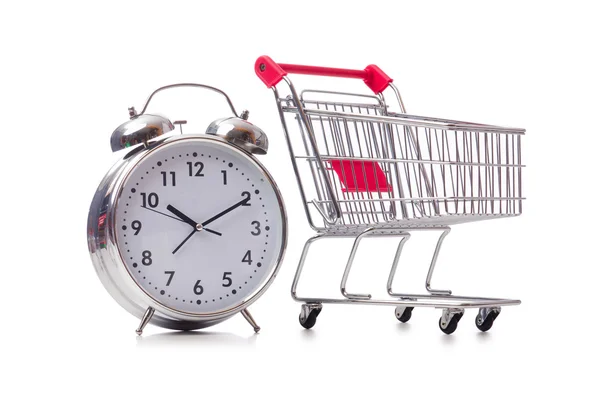 Big alarm clock in shopping cart on white — Stock Photo, Image