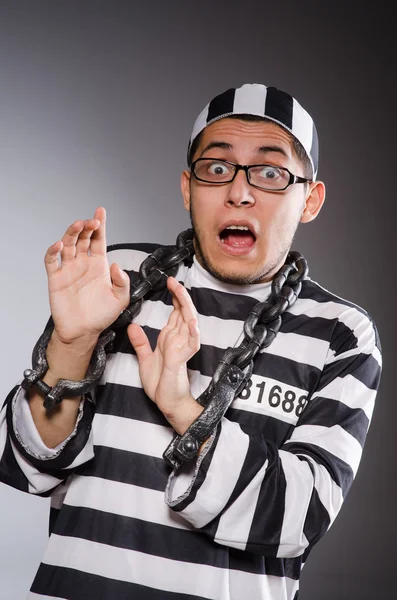 Young prisoner in chains against gray — Stock Photo, Image