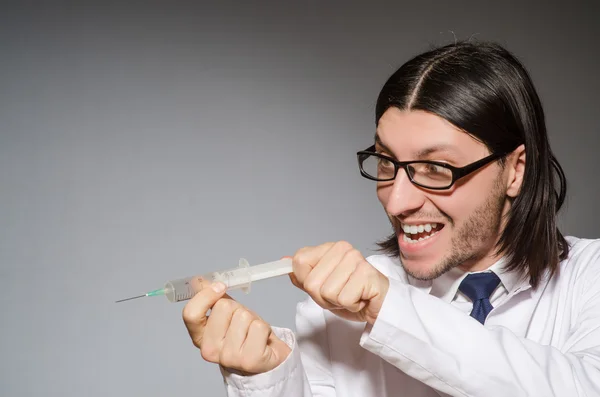 Médico masculino segurando seringa contra cinza — Fotografia de Stock