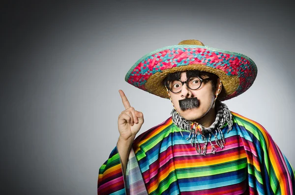 Man in levendige Mexicaanse poncho tegen grijs — Stockfoto
