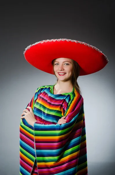 Menina em mexicano poncho vívido contra cinza — Fotografia de Stock