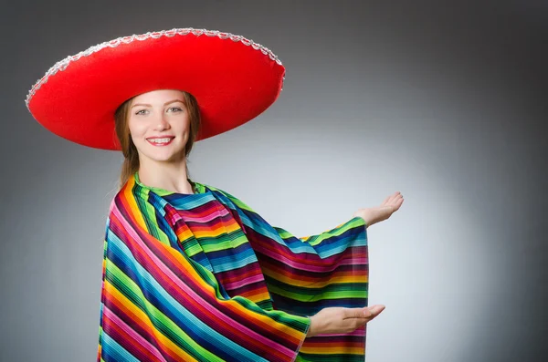 Menina em mexicano poncho vívido contra cinza — Fotografia de Stock