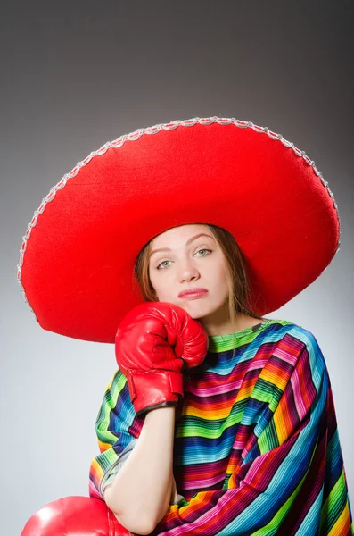 Menina em mexicano poncho vívido e luvas de caixa contra cinza — Fotografia de Stock